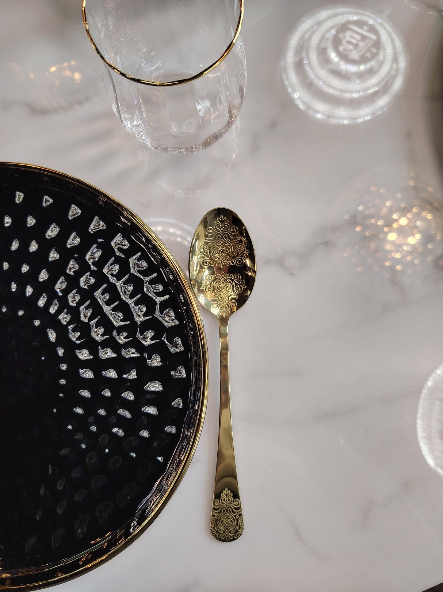 Assiettes noires et dorées du service de table HomeDeLuxe, décor élégante et sophistiquée pour la vaisselle.