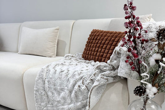 Canapé Coco en velours blanc cassé de HomeDeLuxe, assise confortable avec coussins, design moderne pour salon élégant.