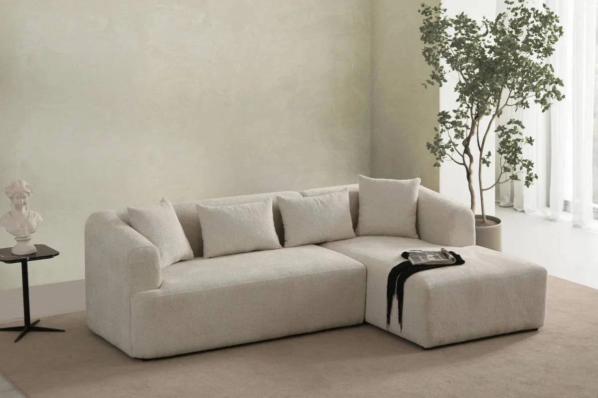 Canapé d'angle en chenille blanc cassé de HomeDeLuxe, avec coussins moelleux et structure moderne visible sur la photo.