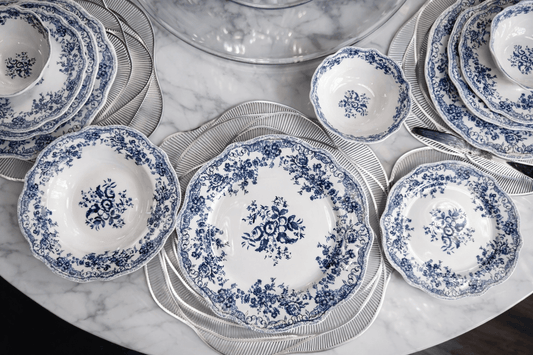 Service de table bleu de la marque HomeDeLuxe avec assiettes, tasses et couverts assortis sur une table élégante.