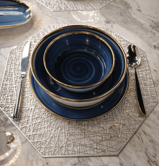 Service de table bleu et doré HomeDeLuxe avec assiettes, tasses et couverts élégants pour repas raffinés.