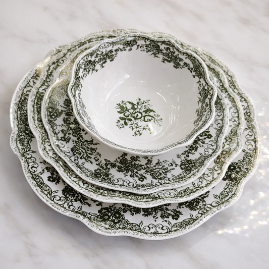 Service de table vert de la marque HomeDeLuxe avec assiettes, verres et couverts disposés sur la table.