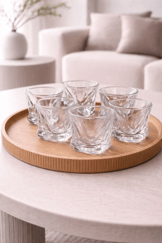 Six verres Twist en verre transparent de la marque HomeDeLuxe, avec design élégant et moderne, disposés sur une surface blanche.