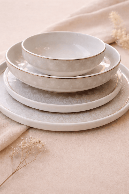 Service de table Allure de HomeDeLuxe avec assiettes élégantes et couverts, disposés sur une table pour un repas sophistiqué.