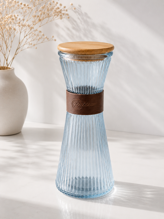 Carafe bleue en verre de marque HomeDeLuxe, élégante et transparente, idéale pour servir boissons dans la cuisine ou la table.