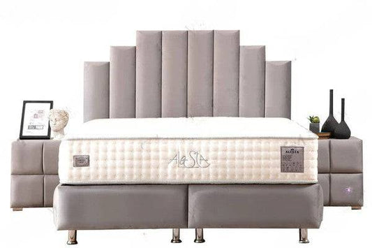 Lit coffre HomeDeLuxe Natura en velours gris avec tête de lit rembourrée et espace de rangement intégré, vue de face dans une chambre élégante