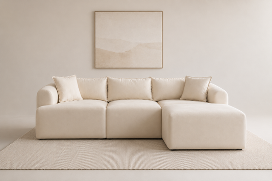 Canapé modulable Mila en velours blanc cassé de HomeDeLuxe, avec coussins et structure élégante visible sur l’image.