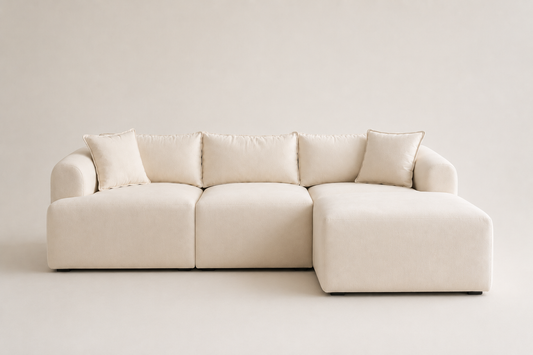 Canapé modulable Mila en velours blanc cassé, design élégant, avec coussins, pour salon moderne et confortable.