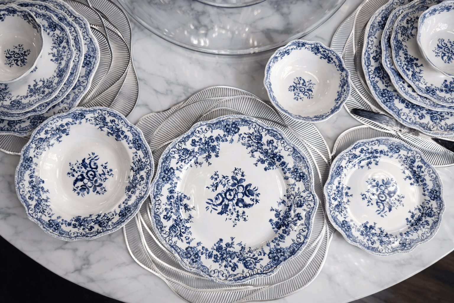 Service de table bleu de la marque HomeDeLuxe avec assiettes, tasses et couverts assortis sur une table élégante.