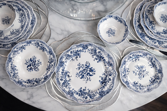 Service de table bleu de la marque HomeDeLuxe avec assiettes, tasses et couverts assortis sur une table élégante.