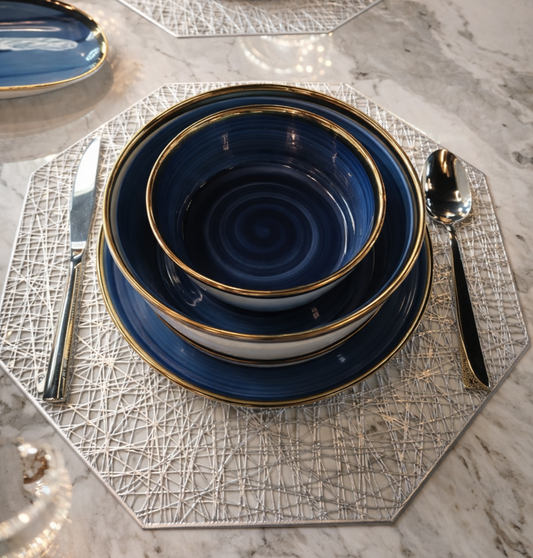 Service de table bleu et doré HomeDeLuxe avec assiettes, tasses et couverts élégants pour repas raffinés.