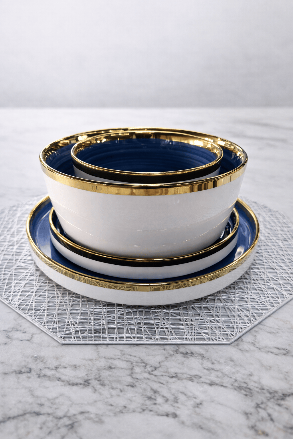Service de table HomeDeLuxe bleu et doré, ensemble élégant avec assiettes et couverts dans une ambiance sophistiquée.