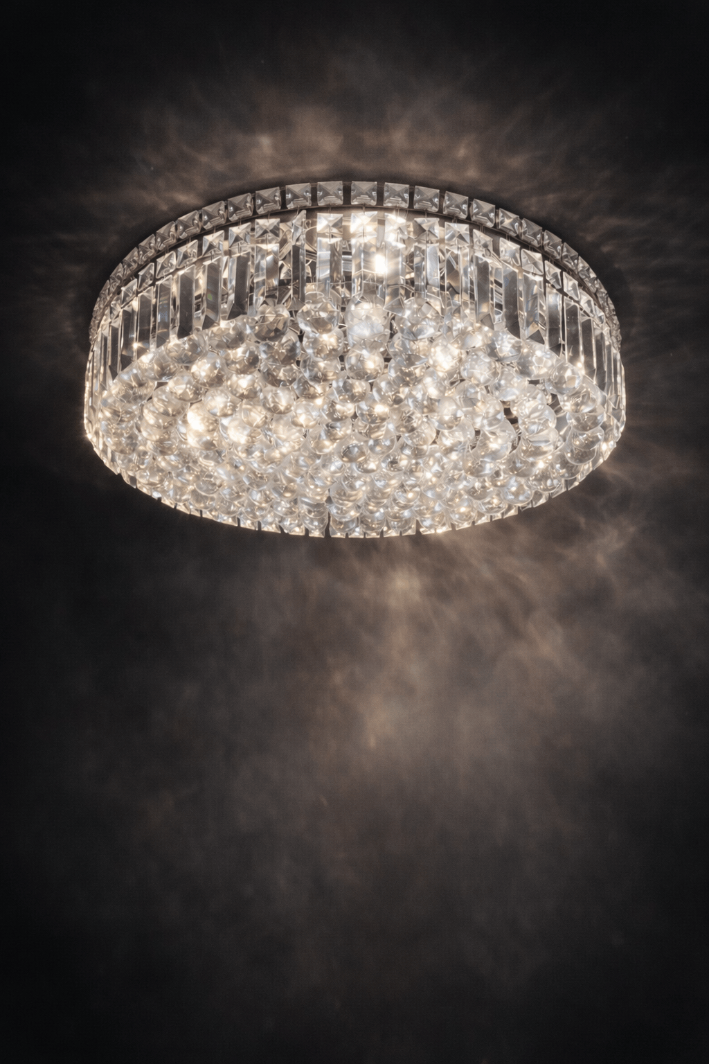 Lustre à boule majestueux de la marque HomeDeLuxe, avec plusieurs boules suspendues en verre transparent.