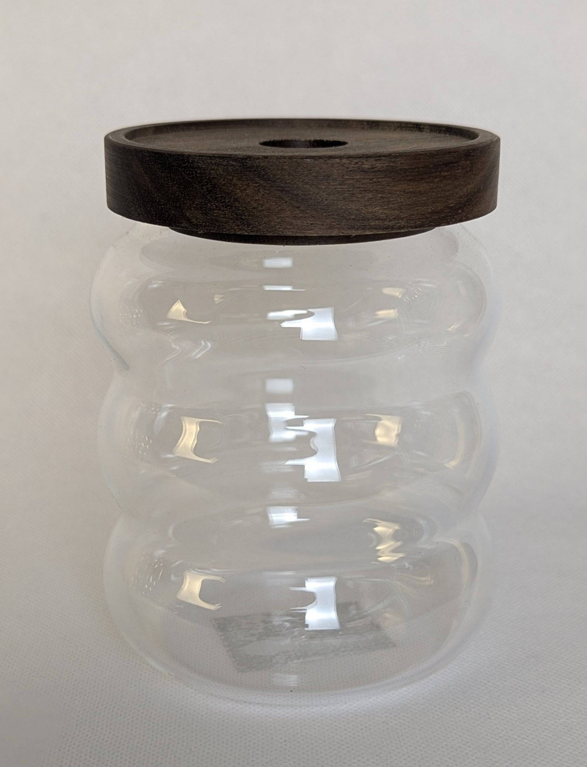 Petit bocal en verre HomeDeLuxe avec couvercle, idéal pour stockage alimentaire ou décoration.
