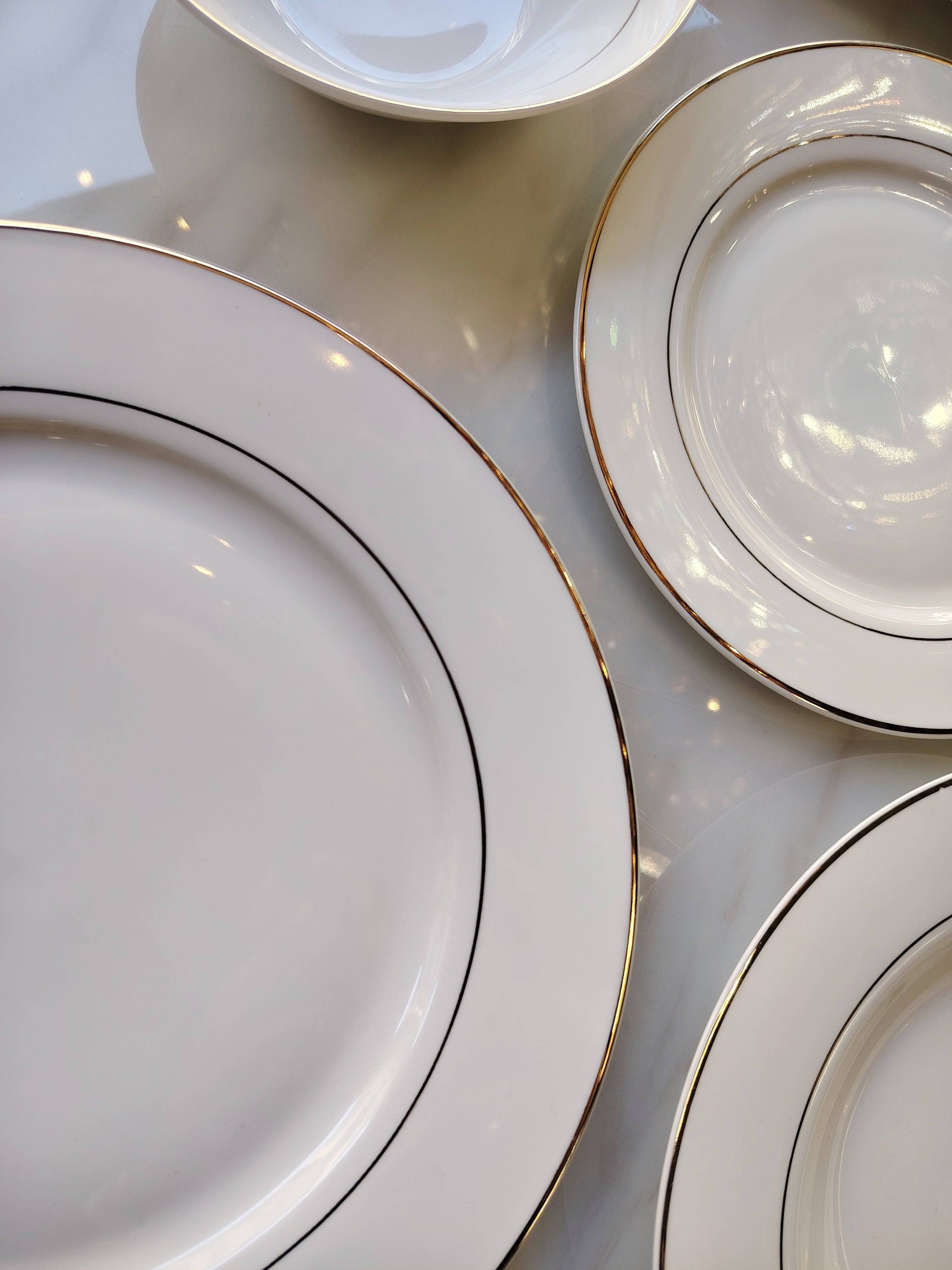Service de table HomeDeLuxe avec liseré doré, set élégant de vaisselle pour repas sophistiqués, visible sur l'image.