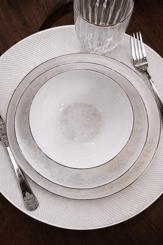 Service de table Prestige de HomeDeLuxe avec assiettes élégantes et vaisselle raffinée pour une table sophistiquée.