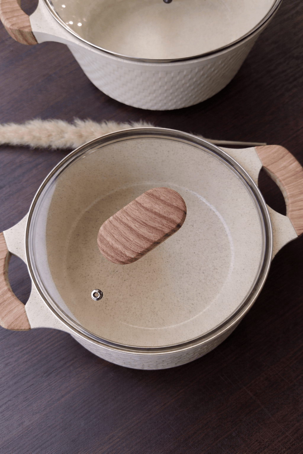 Quatre marmites HomeDeLuxe Harmony en acier inoxydable, avec poignées en bakélite, parfaites pour cuisine moderne.