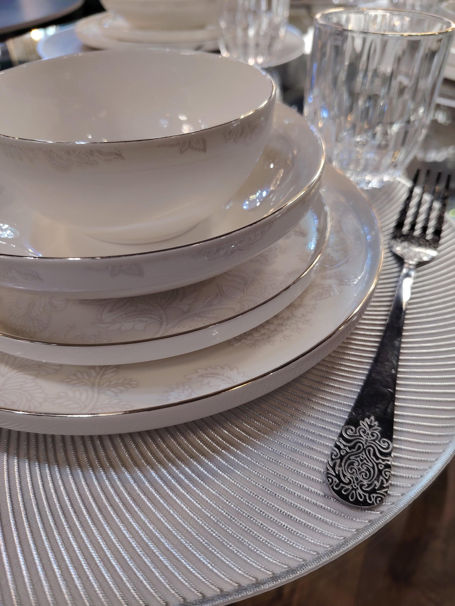 Service de table Prestige de HomeDeLuxe avec assiettes élégantes, verres et couverts pour une présentation raffinée.