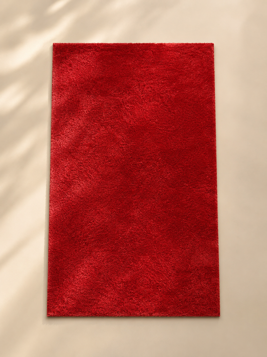 Tapis rouge petit, design élégant de la marque HomeDeLuxe, avec motif simple et texture douce visible sur l'image.
