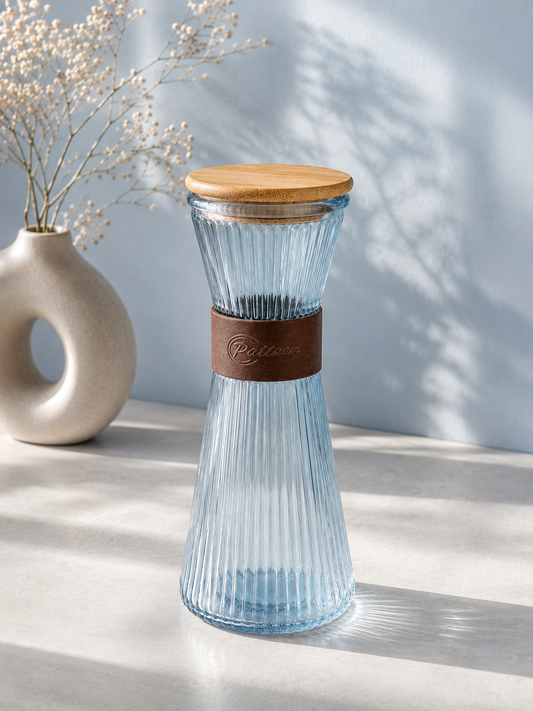 Carafe bleue en verre de marque HomeDeLuxe avec bouchon, vue de face sur fond blanc.