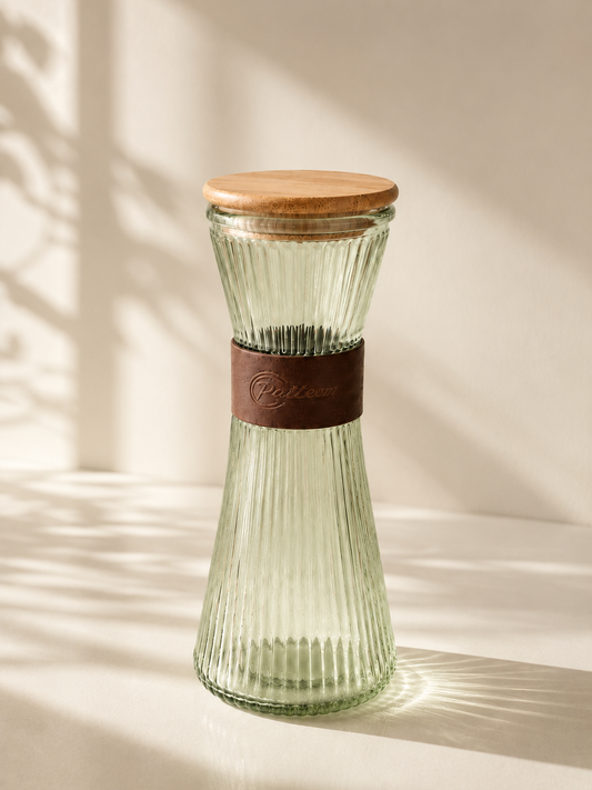 Carafe verte en verre de la marque HomeDeLuxe, avec un design élégant et transparent, idéale pour servir des boissons.