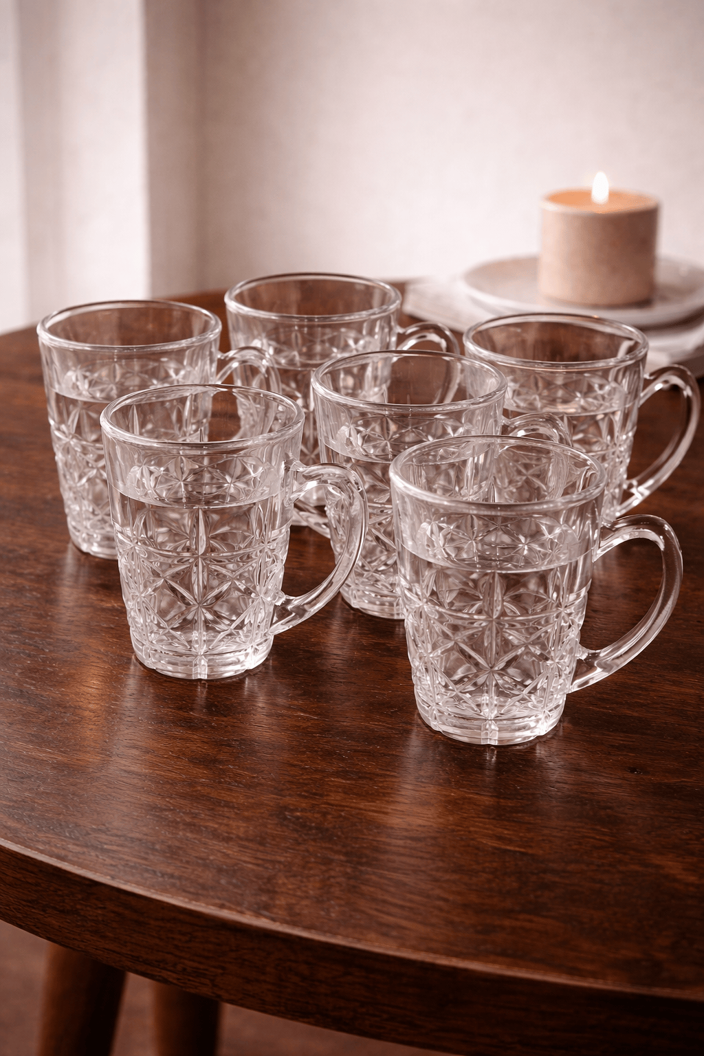 Six verres à café en verre transparent de la marque HomeDeLuxe, empilés sur une surface lumineuse.