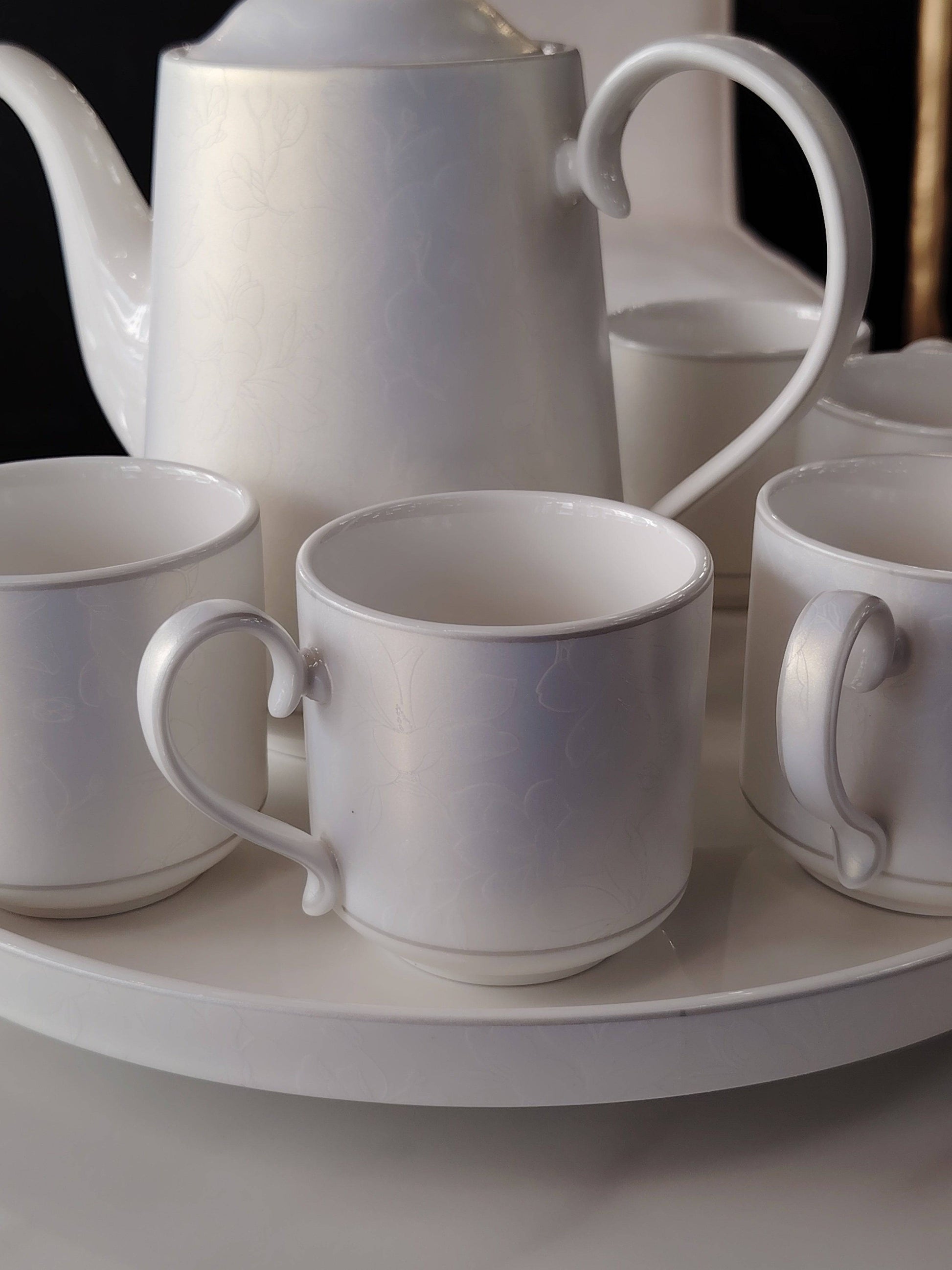 Service à thé et café irisé de HomeDeLuxe avec tasses et théière élégantes en céramique colorée.